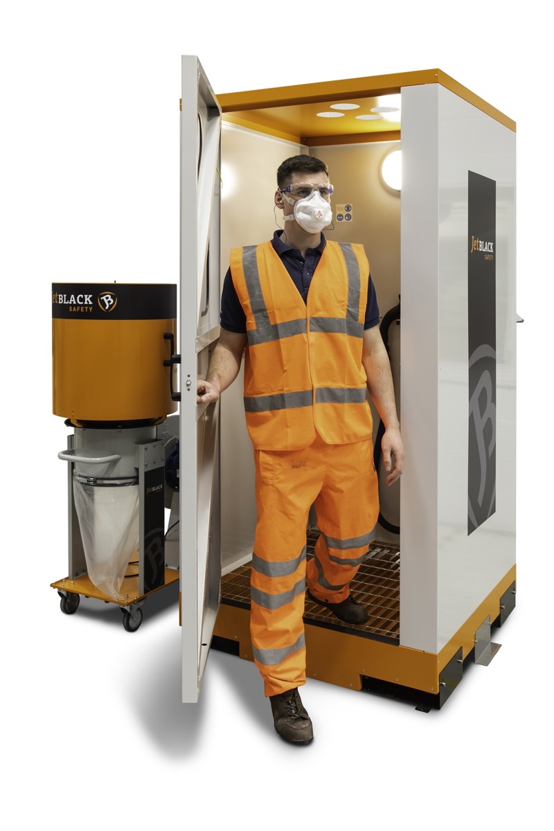 Worker in PPE exiting a JetBlack Safety personnel cleaning booth (standard)